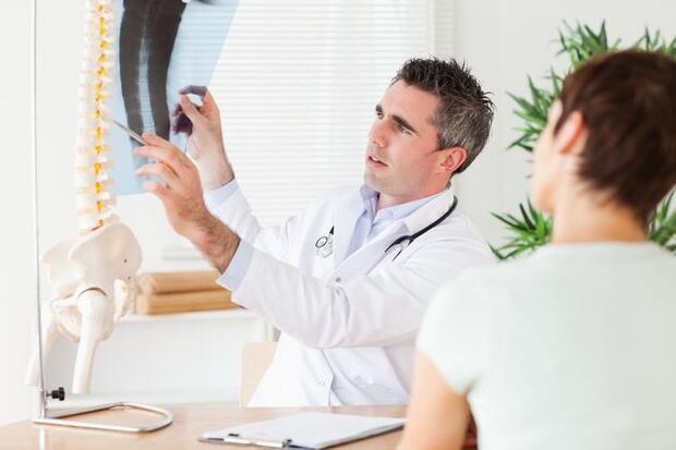 le médecin montre des dommages à la colonne vertébrale dus à l'ostéochondrose cervicale